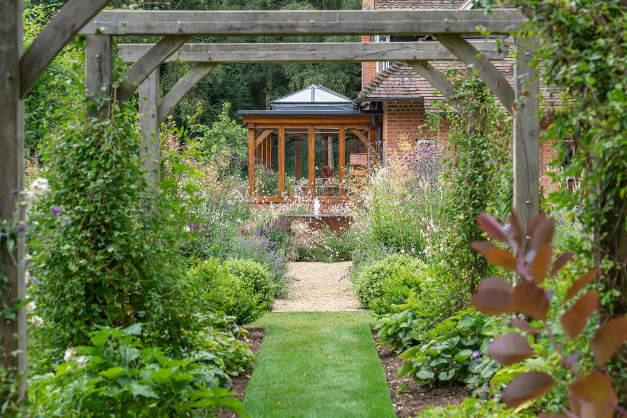 Garden path bordered by flowers leading to water feature