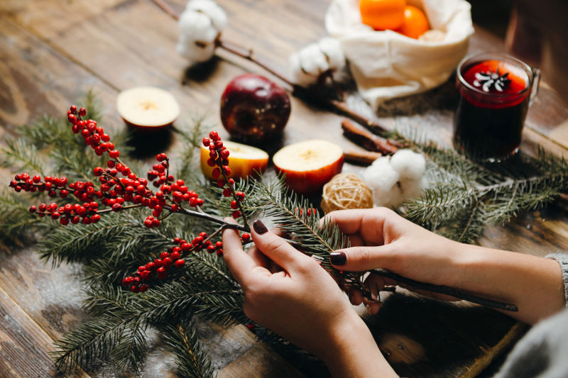 Adding red berries to a Christmas wreath