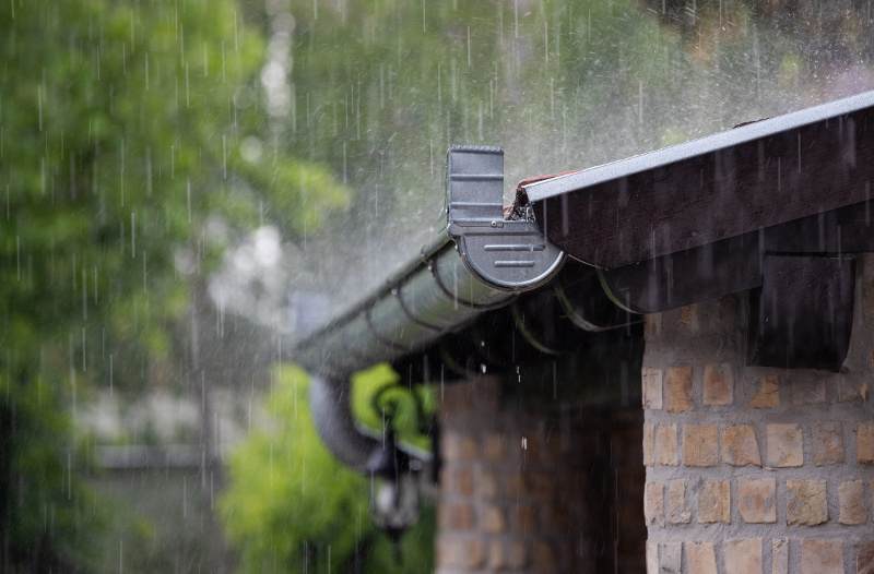 Heavy rain falling on roof and gutter